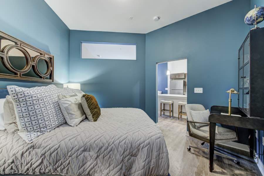 Apartment bedroom with a small desk and rolling chair